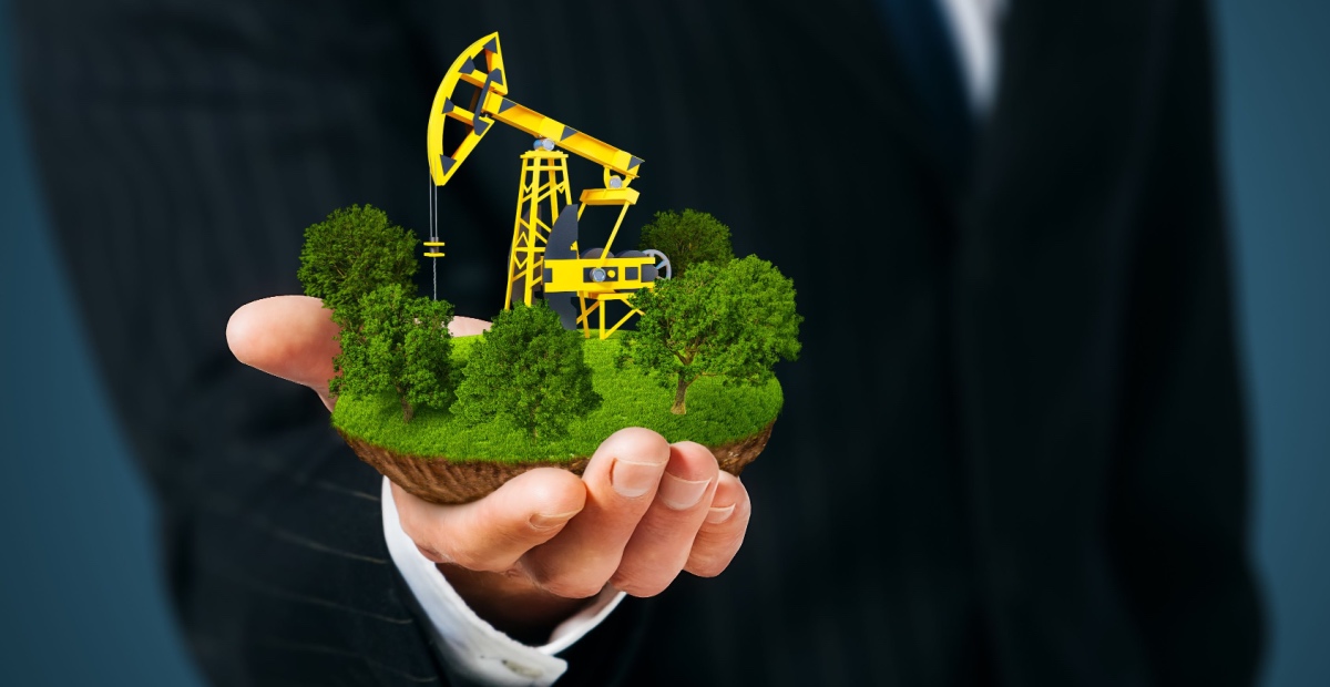 Hand holds oil pump amid greenery