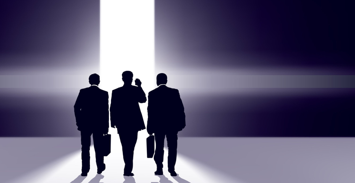 Three suited men walk towards the light