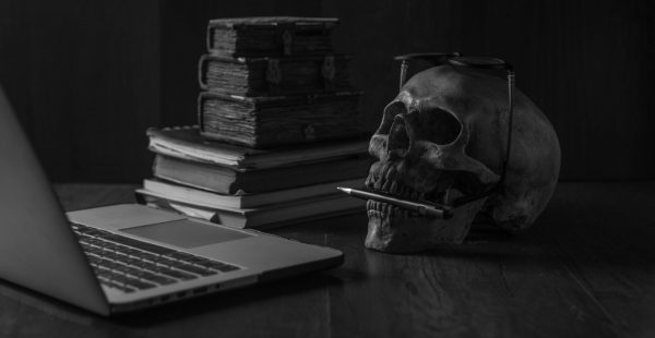 Skull, laptop and old books