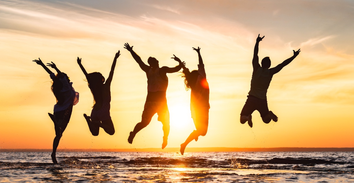 Figures jumping at sunset