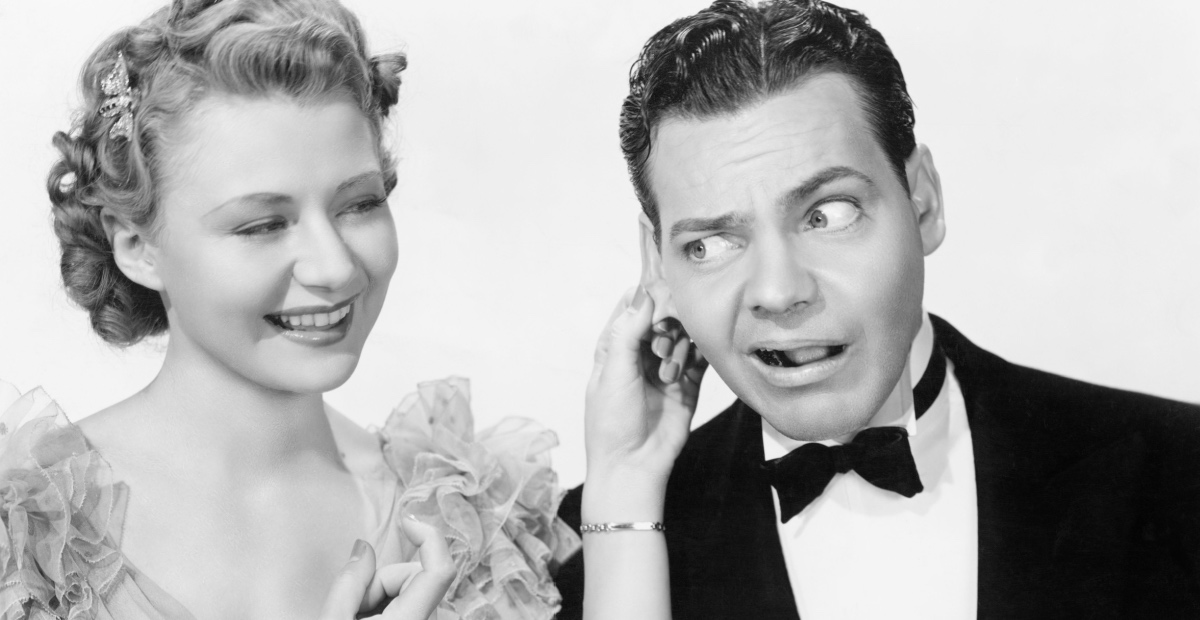Coy woman pulls man's ear