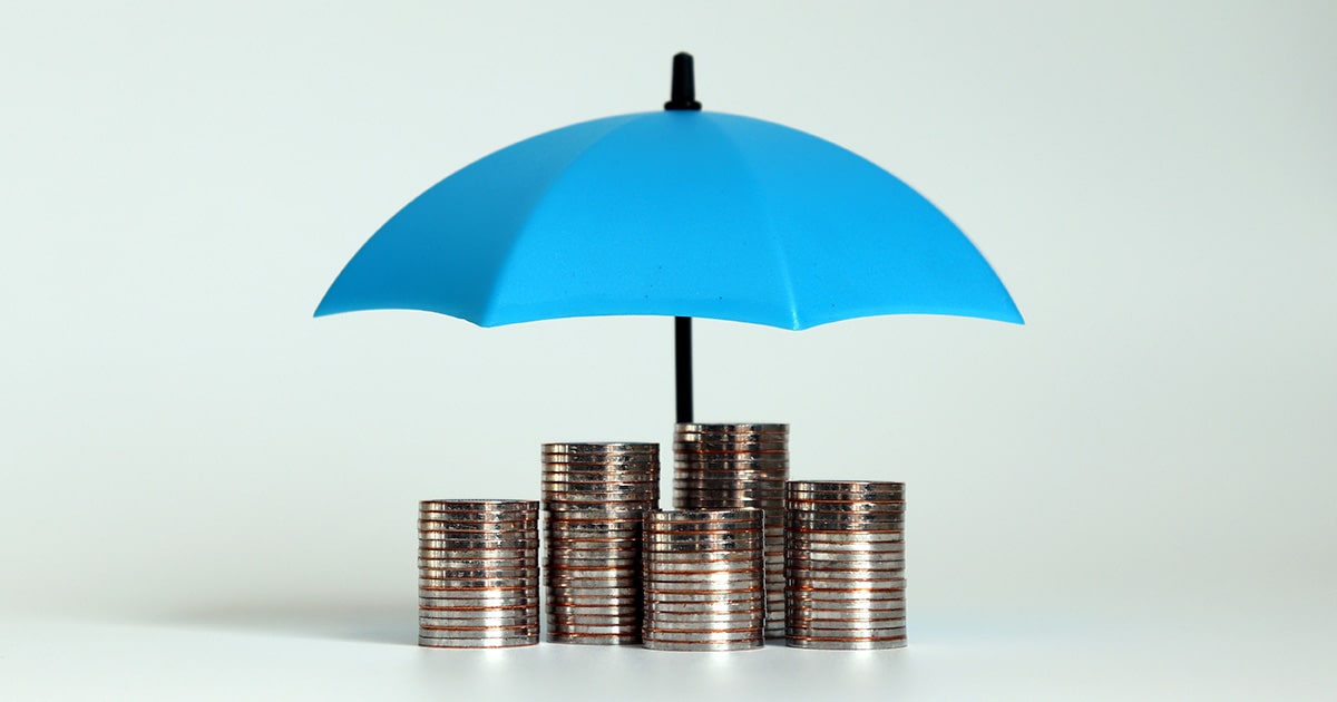 Coins stacked in piles underneath an umbrella