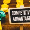 Sign on table saying Competitive Advantage with scrunched up paper balls