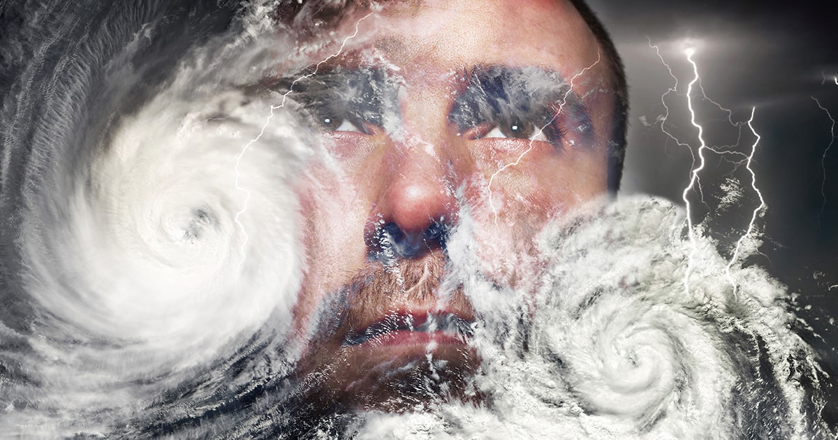 Man's face superimposed behind two cyclones