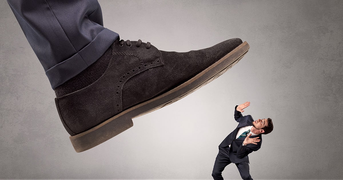 Large foot stepping on businessman