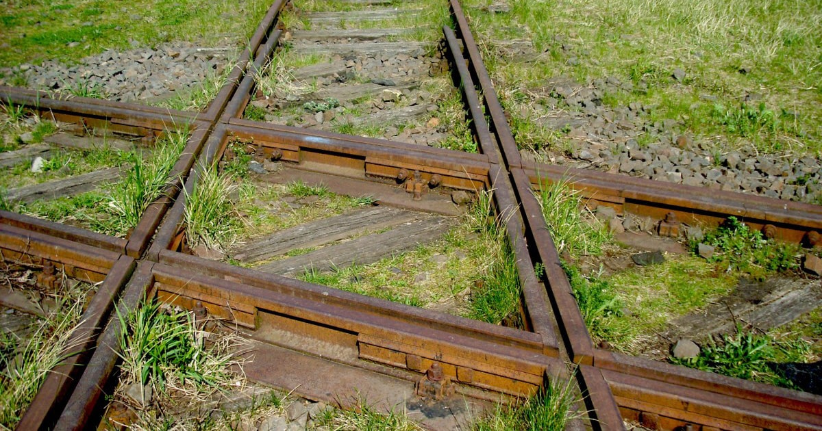 Old railway tracks intersecting on grass