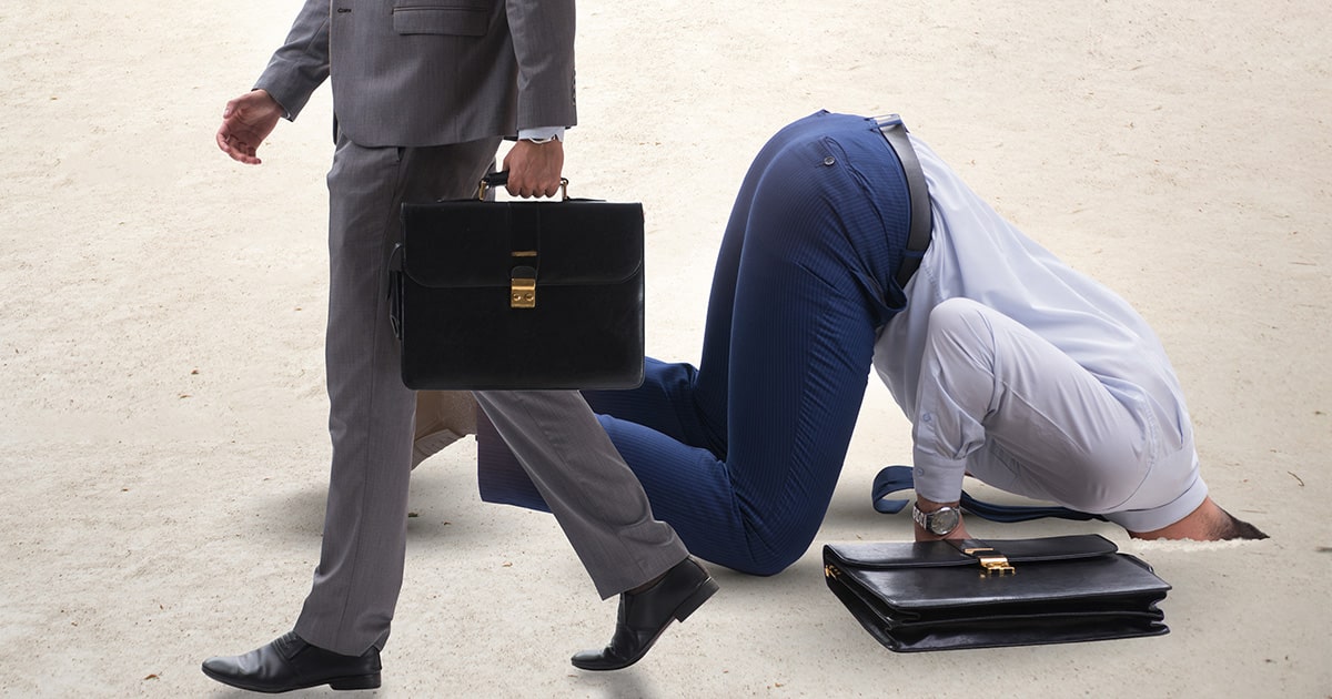 Businessman with his head in the sand