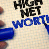 High Net Worth being written on grid paper with blue marker