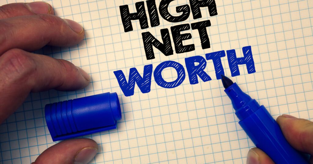 High Net Worth being written on grid paper with blue marker