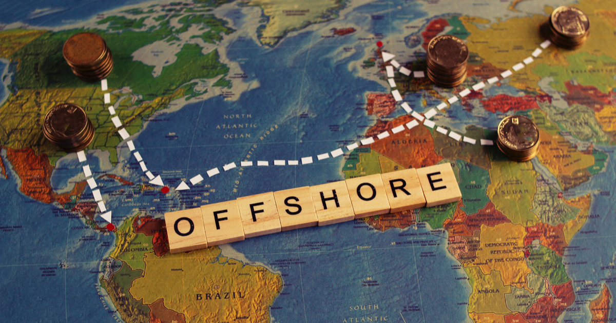 Offshore spelt out in wooden blocks on a world map with coins