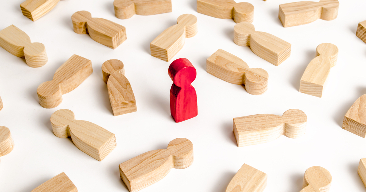 Wood figures lying down with red figure standing up