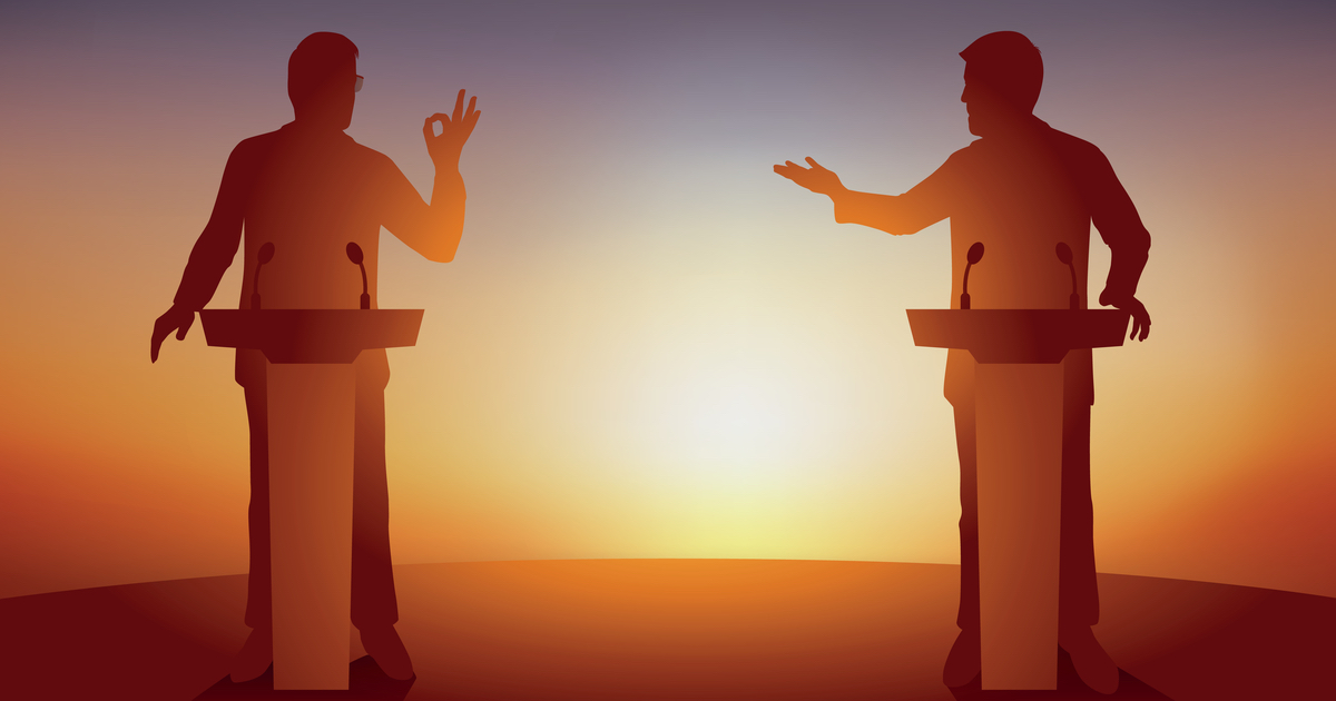 Two figures standing at lecterns debating