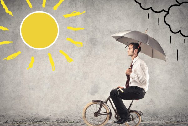 Businessman riding a bike with an umbrella in sunny and rainy weather