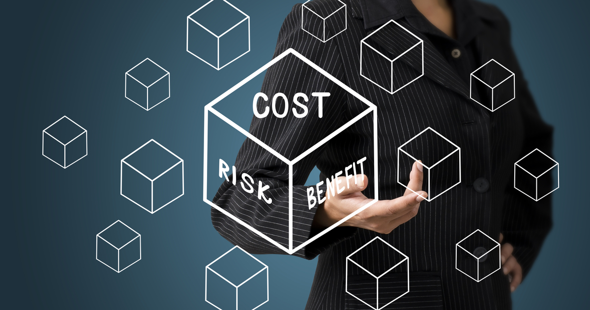 Woman pointing to cube with Cost, Risk and Benefit written
