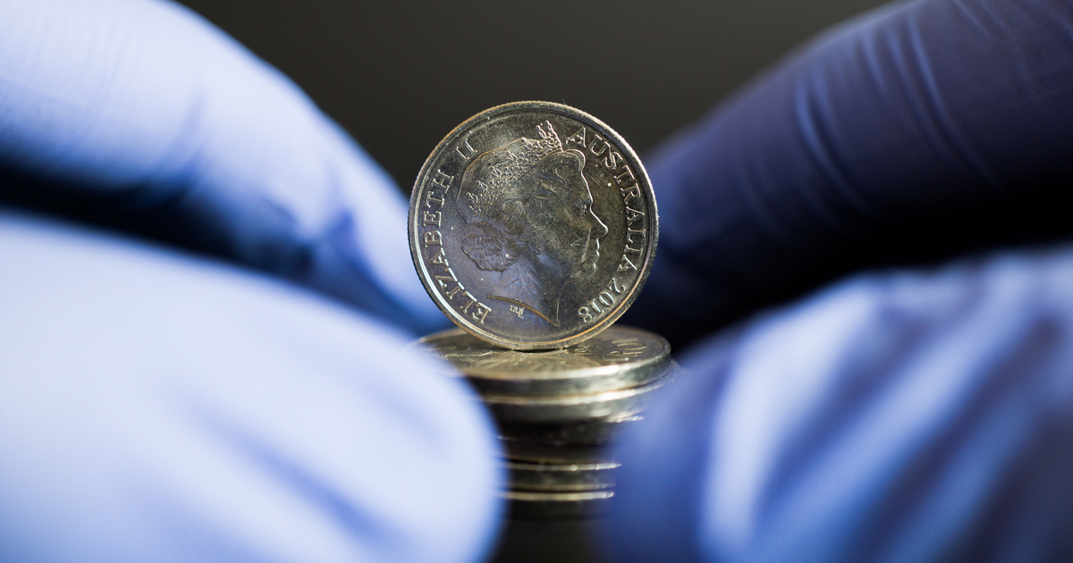 Gloved hand holding coins