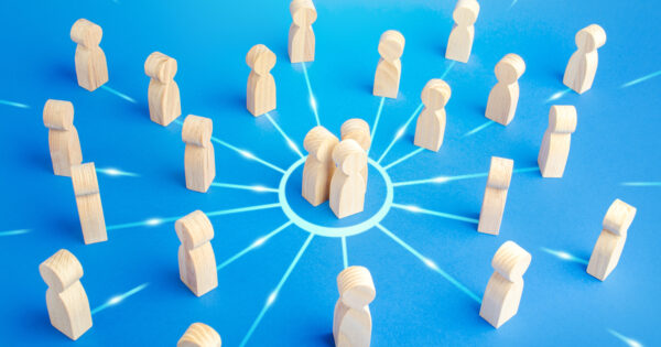 Wooden figures grouped inside a circle and standing outside