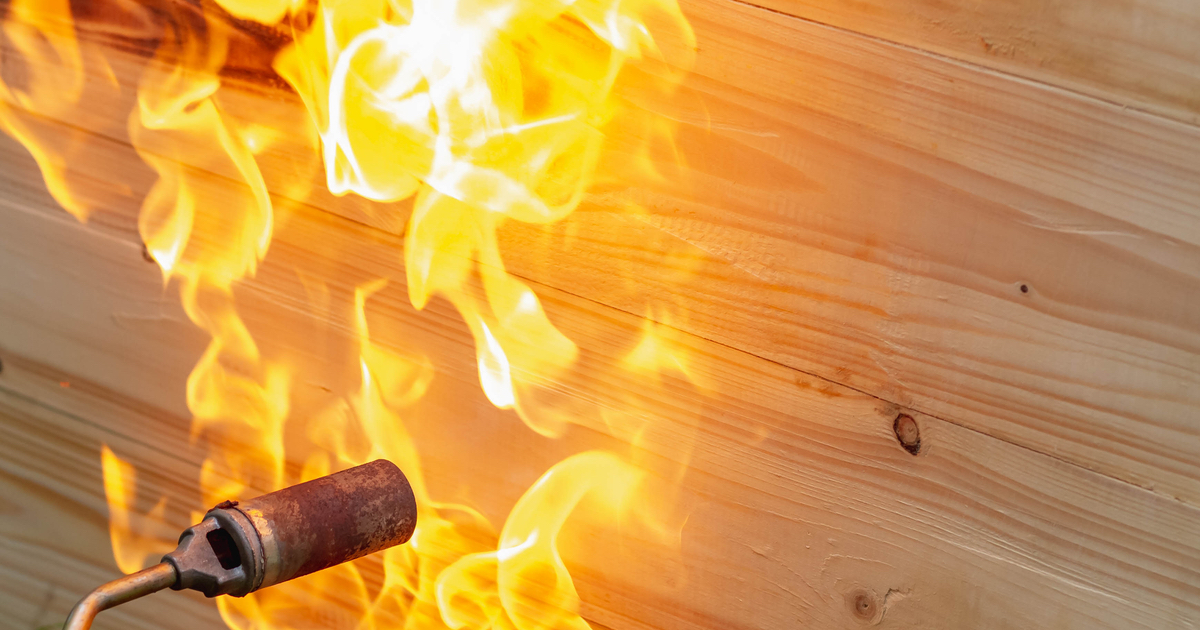 Blowtorch against wooden wall