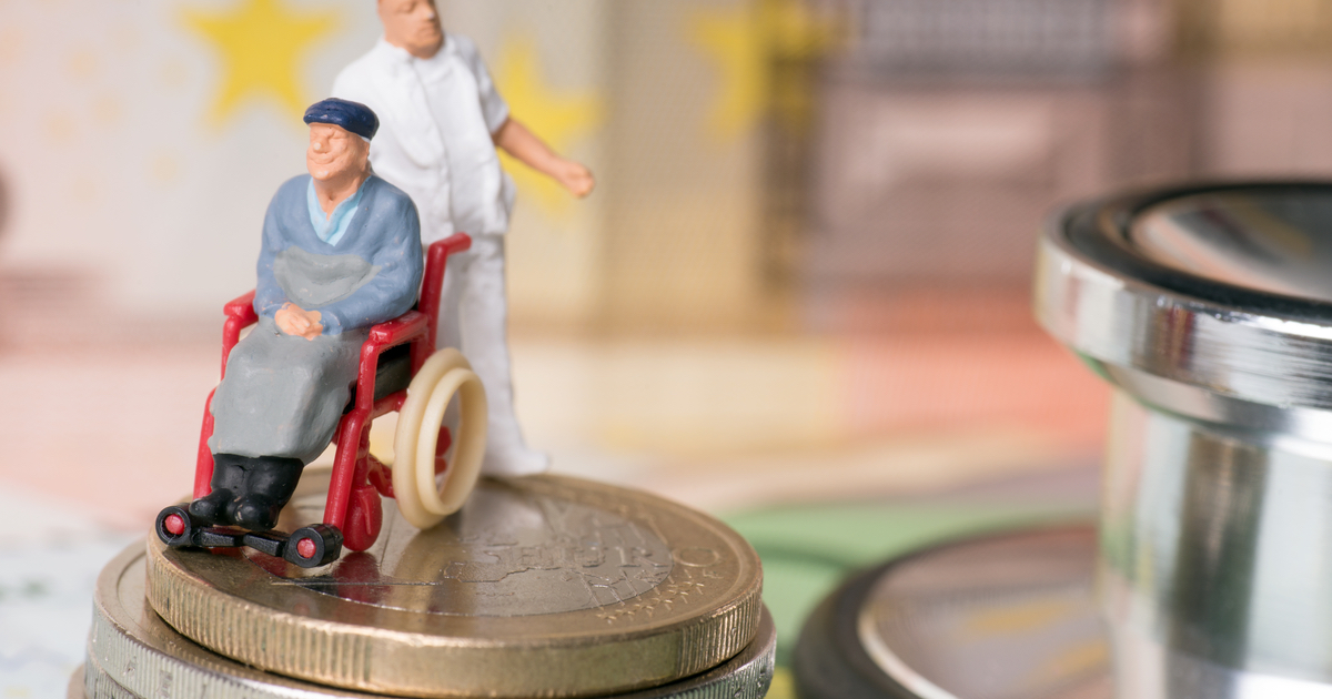 Figures of aged carer and man in wheelchair on top of coins