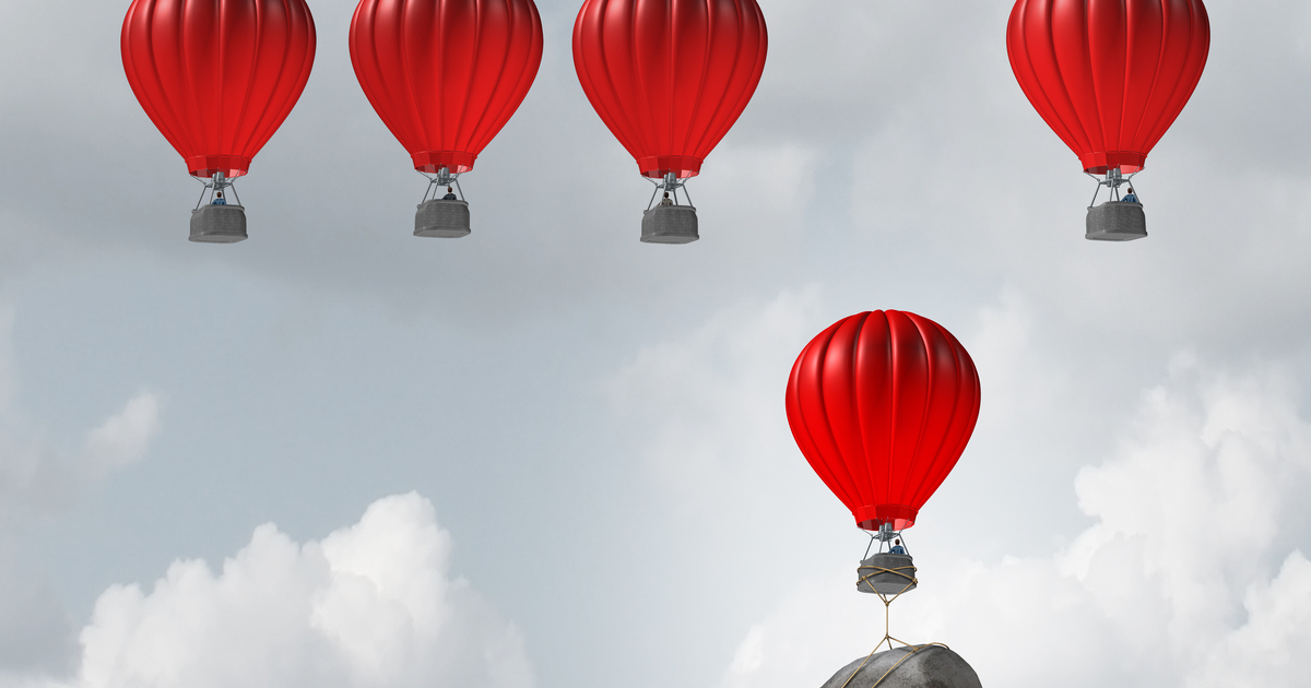 5 red hot air balloons rising into the sky with 1 weighted down