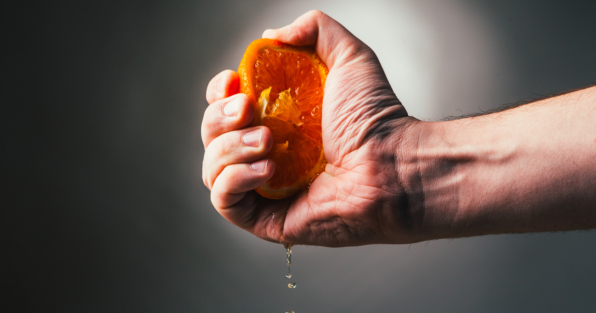 Hand squeezing an orange