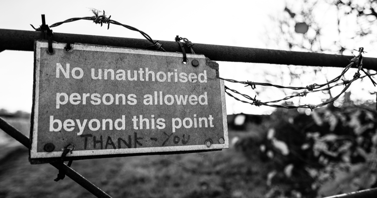 No unauthorised persons allowed beyond this point sign with barbed wire