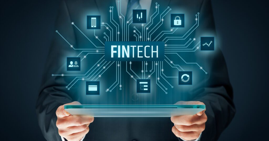 Man in suit holding a tablet with the word Fintech above it
